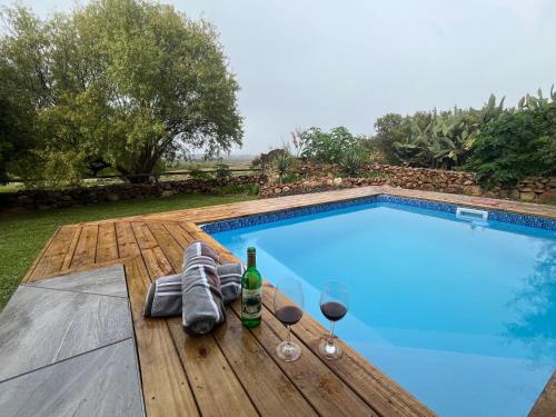 a pool with a table with glasses and wine bottles at Welbedacht Game & Nature Reserve in Tulbagh