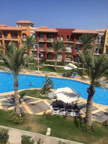 an aerial view of a resort with a pool and palm trees at سانتورين الساحل الشمالي in Marsa Matruh