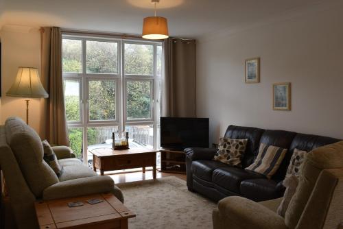 a living room with a couch and a tv at Flat 18 Pochin House in St Austell
