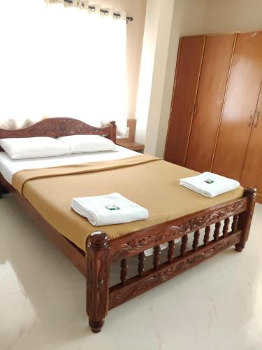 a bedroom with a bed with two towels on it at Nandan Suits in Mysore