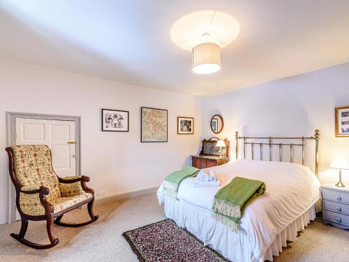 a bedroom with a bed and a chair at Ghyll View in Gunnerside