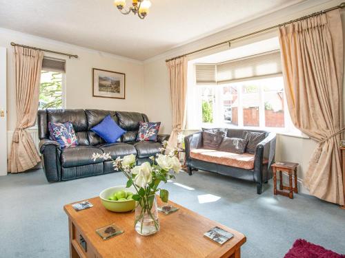 Una sala de estar con un sofá de cuero y una mesa. en Squirrels, en Teignmouth