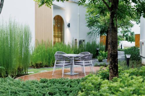 two chairs and a table in a garden at Naris phu view resort in Ban Pan Cho