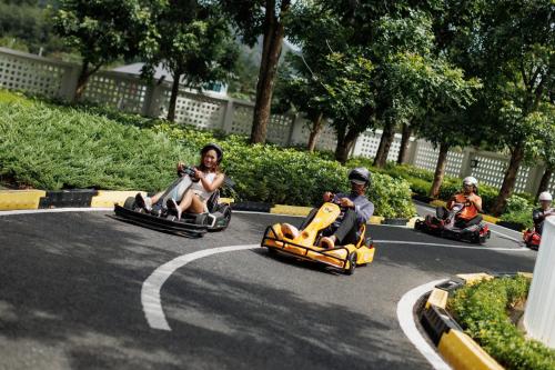 a group of people riding on toy cars on a road at Naris phu view resort in Ban Pan Cho