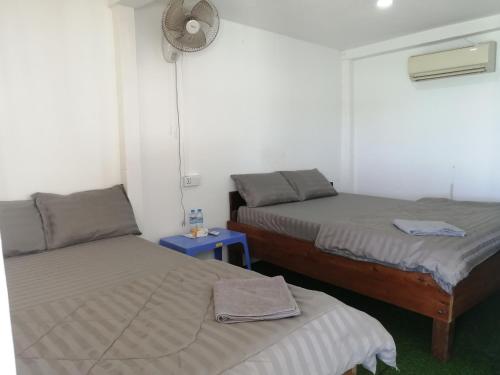 a bedroom with two beds and a blue table at SokSan Seaview Cottage in Koh Rong Island