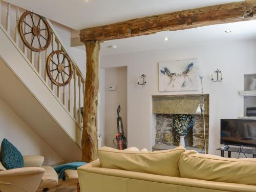 a living room with a couch and a fireplace at Cartwheel Cottage in Hawes