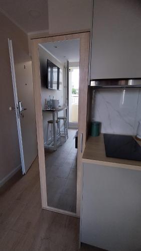 a kitchen with a door leading to a dining room at Super Central studio with Balcony & View! in Warsaw
