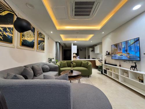 a living room with a couch and a tv at Skyline Executive Apartments By Gold Crest Mall-DHA LAHORE in Lahore