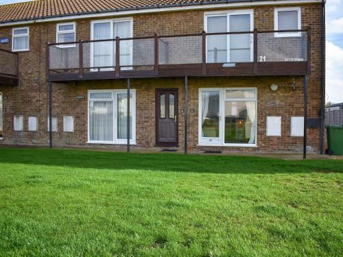 a brick house with a green lawn in front of it at Mr Seal - Uk41452 in Hunstanton