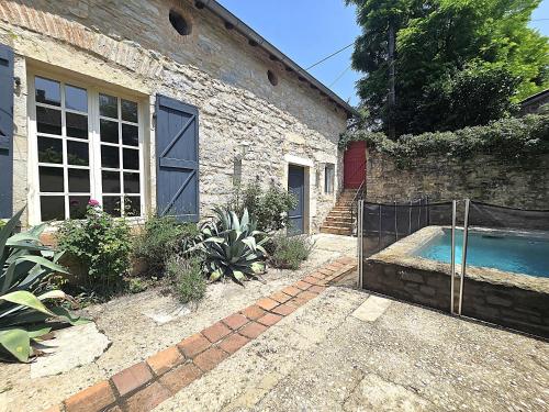 une maison avec une piscine à côté d'un bâtiment dans l'établissement Magnifique villa en pierres au cœur de Saint Antonin Noble Val - Piscine et jardin privés -10 personnes, à Saint-Antonin