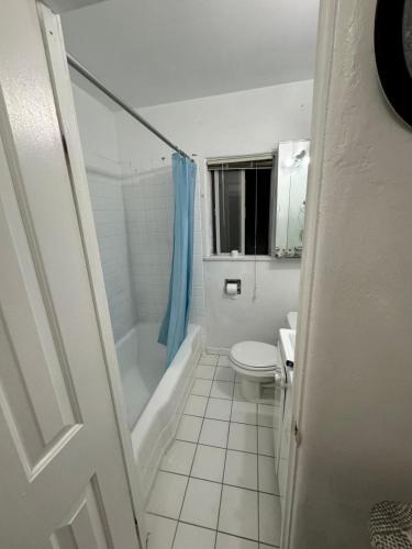 a bathroom with a toilet and a tub and a sink at Females room bunk beds in Los Angeles