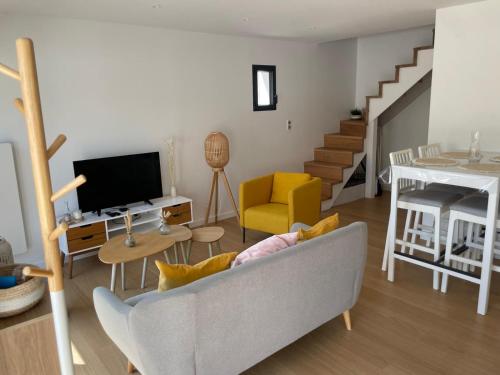 un salon avec un canapé et une télévision dans l'établissement Maison 2 ch proche plages Anglet, à Anglet