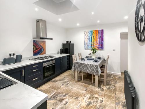 a kitchen with a table and a dining room at The Alnwick Townhouse in Alnwick