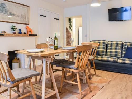 Un comedor con mesa y sillas de madera. en Ring Of Bells, en South Molton