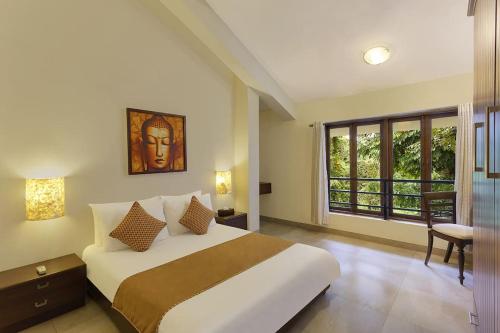 a bedroom with a large bed and a window at 5 Tropical Woods 4 BR VillaGoa Pool Cook in Bardez