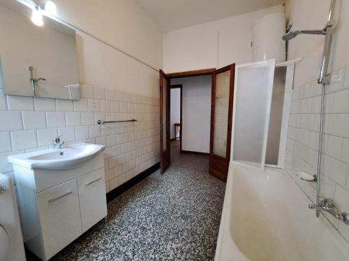 a bathroom with a sink and a tub and a toilet at GREEN DOLOMYTE Apartment in Schilpario
