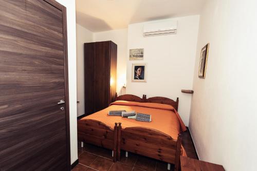 a small bedroom with a bed with orange sheets at Nella Sardegna più autentica, Lollovers in Lollove