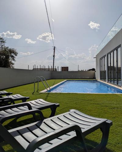 a swimming pool with lounge chairs next to a building at Casa do Poço in Miranda do Douro