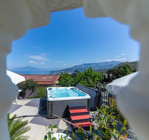 a hot tub on a patio with mountains in the background at Hotel Iaccarino in SantʼAgata sui Due Golfi