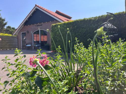 a garden with flowers in front of a building at Vakantiewoning 't Linderveld in Rossum