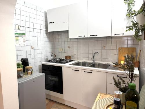 a kitchen with white cabinets and a sink at La Dolce Casa Centre Free Parking Family in Celano