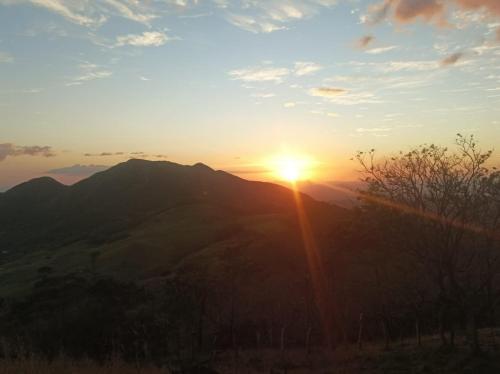 a sunset over a mountain with the sun setting at Hospedaje Rancho mi Tata in Solania