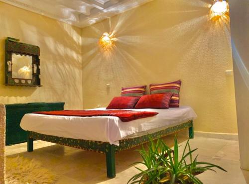 a bedroom with a bed with red pillows at à 5 minutes de Seguia Beach résidence in Midoun