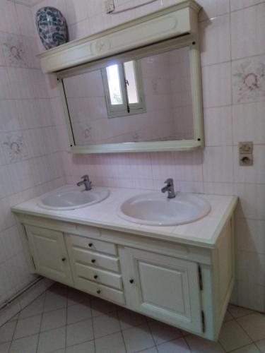 une salle de bain avec deux lavabos et un miroir dans l'établissement 1 er étage, à Lunel-Viel