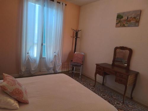 une chambre avec un lit, une table et une chaise dans l'établissement 1 er étage, à Lunel-Viel
