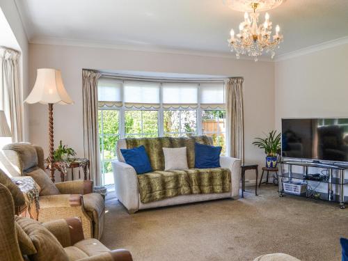 a living room with a couch and a tv at Corner Cottage in Sewerby