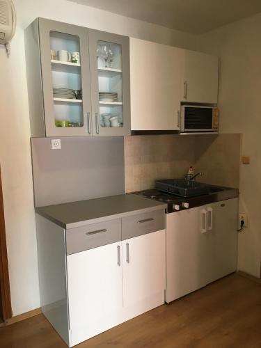a kitchen with white cabinets and a counter top at Apartments Villa More in Makarska