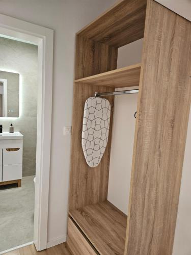 a wooden door in a bathroom with a mirror at Lendas Apartments & Rooms in Baška Voda