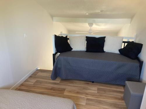 une chambre avec un lit avec des oreillers noirs et blancs dans l'établissement La franqui , nouveau , Duplex pour 2 ou 3 ,piscine, mer ,soleil , station familiale, à La Franqui-Plage