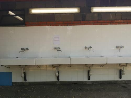 a row of sinks in a public bathroom at Nuraghe Ruiu Villaggio Tende Attrezzate in Norbello