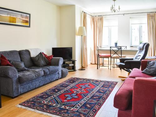 a living room with a couch and a rug at Lime Court - Cottages in Leatherhead