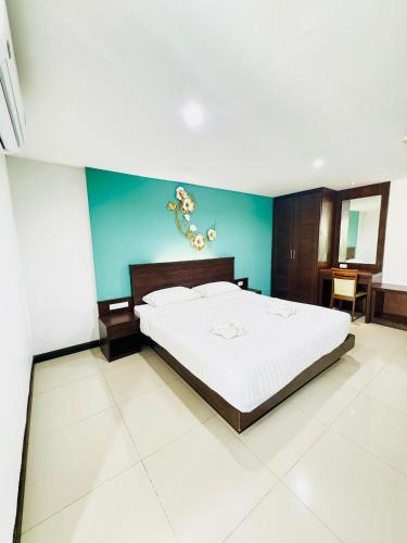 a bedroom with a bed and a blue wall at La Casa Patong in Patong Beach