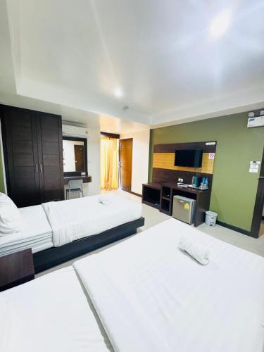 a large bedroom with two beds and a television at La Casa Patong in Patong Beach