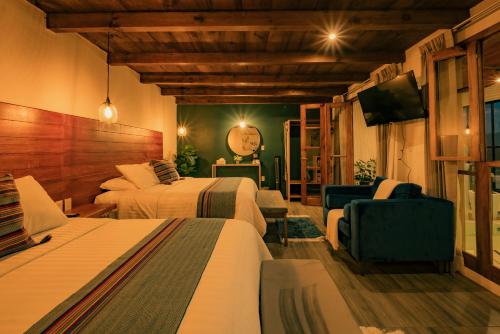 a hotel room with two beds and a television at Na Hotel in San Cristóbal de Las Casas
