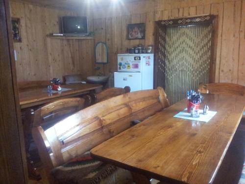 jadalnia z drewnianym stołem i lodówką w obiekcie Shovkova Kosytsia w mieście Mikuliczyn
