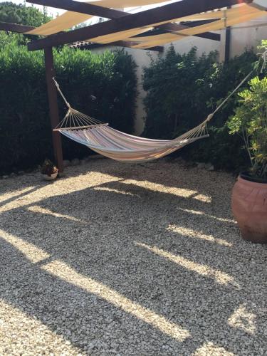 a hammock hanging from a pergola in a garden at Oasi di Campagna in Modica