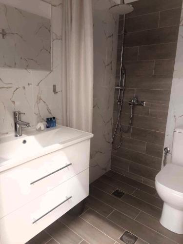 a bathroom with a sink and a shower with a toilet at Galazio suites 2 Seaside in Salamina