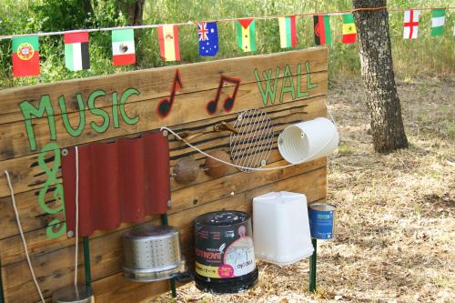 a wooden wall with a music music sign and flags at Nuraghe Ruiu Villaggio Tende Attrezzate in Norbello