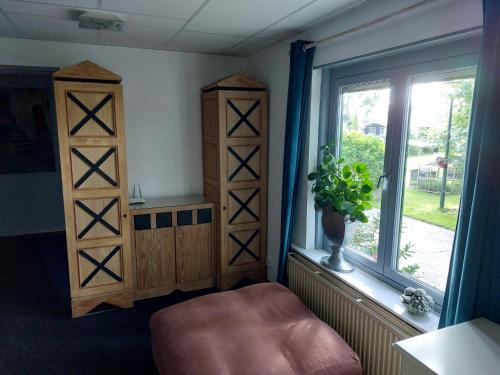 a room with a window and wooden shelves and a chair at Appartement De Molshoop II in Landsmeer