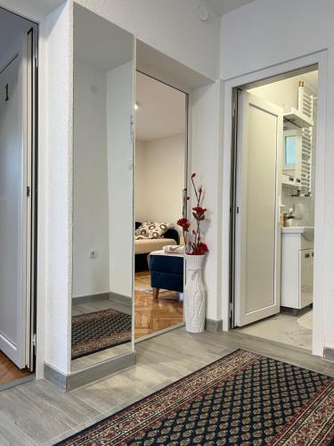 a living room with a mirror and a bedroom at Home Nikolić in Novi Pazar