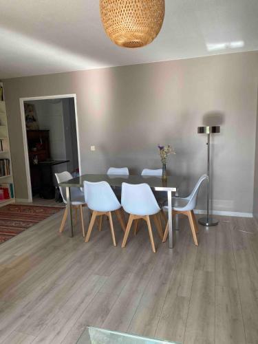 une salle à manger avec une table et des chaises blanches dans l'établissement Bordeaux Grand appartement 2 terrasses calme parc ombrage parking prive, à Bordeaux