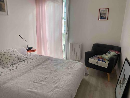une chambre avec un lit, une chaise et une fenêtre dans l'établissement Bordeaux Grand appartement 2 terrasses calme parc ombrage parking prive, à Bordeaux