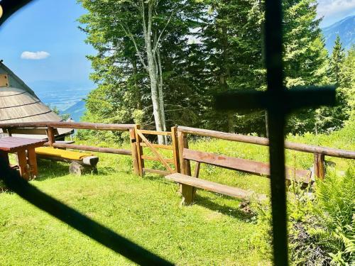 a view of a bench and a cross from a window at Chalet Kanja Velika Planina in Stahovica