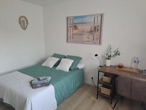 - une chambre avec un lit, un bureau et une photo dans l'établissement Chambre d hôte la rivière 45m2 jardin et piscine, à Aigrefeuille-dʼAunis