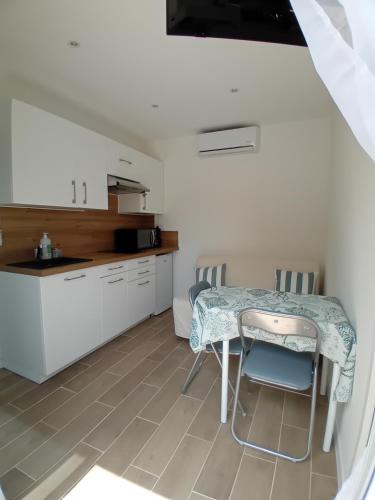 une cuisine avec une table et des chaises dans une pièce dans l'établissement Appartement avec piscine au calme, à Grasse