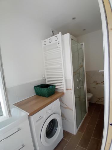 - un lave-linge dans la salle de bains pourvue d'un miroir dans l'établissement Appartement avec piscine au calme, à Grasse